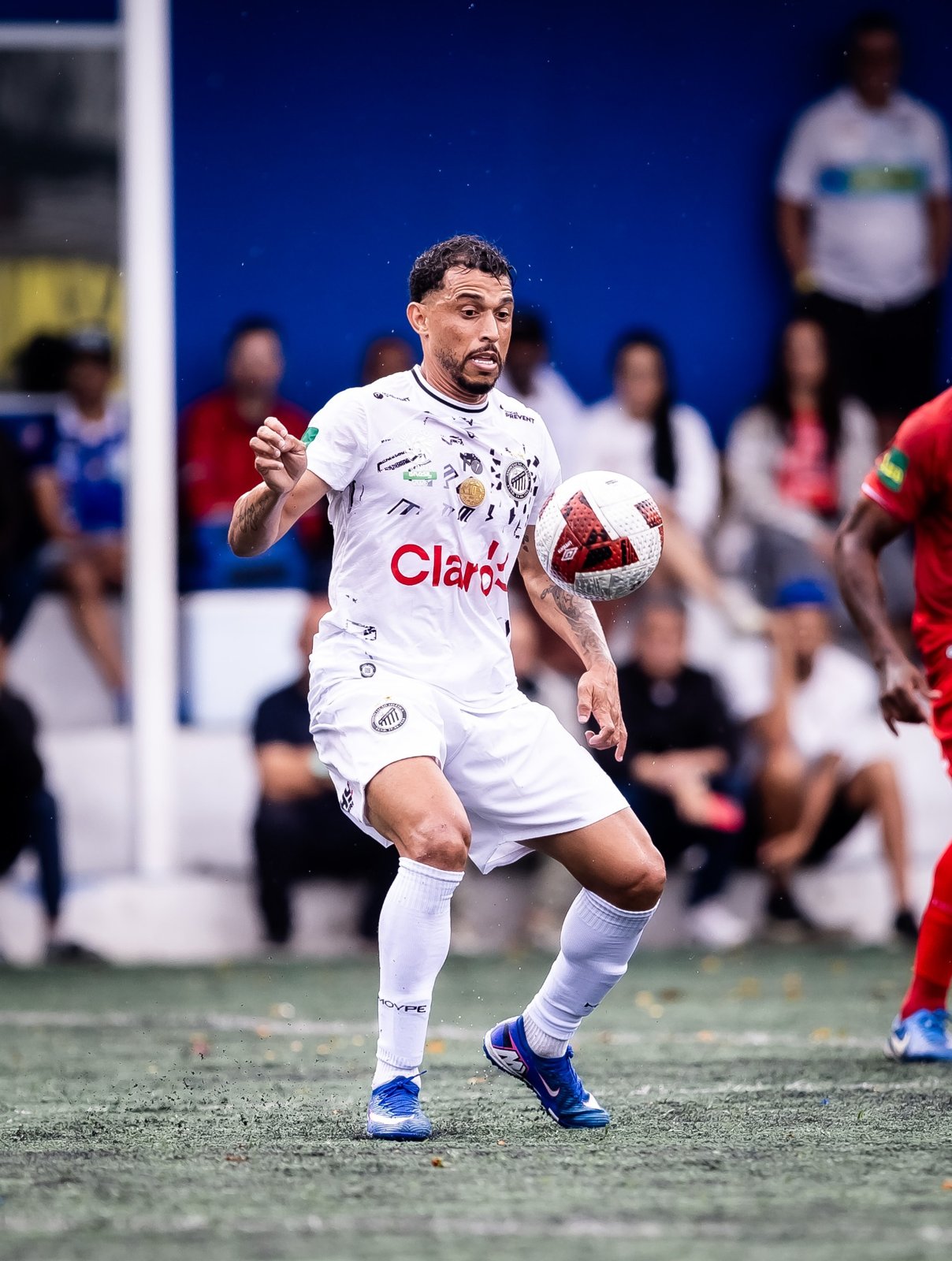 Atleta com uniforme branco e marca Claro nas semifinais