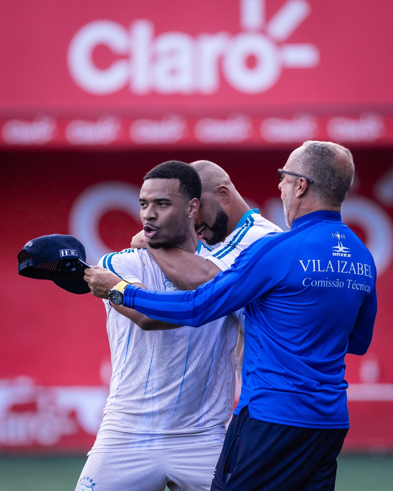 Atleta e integrante da comissão com a marca Claro ao fundo