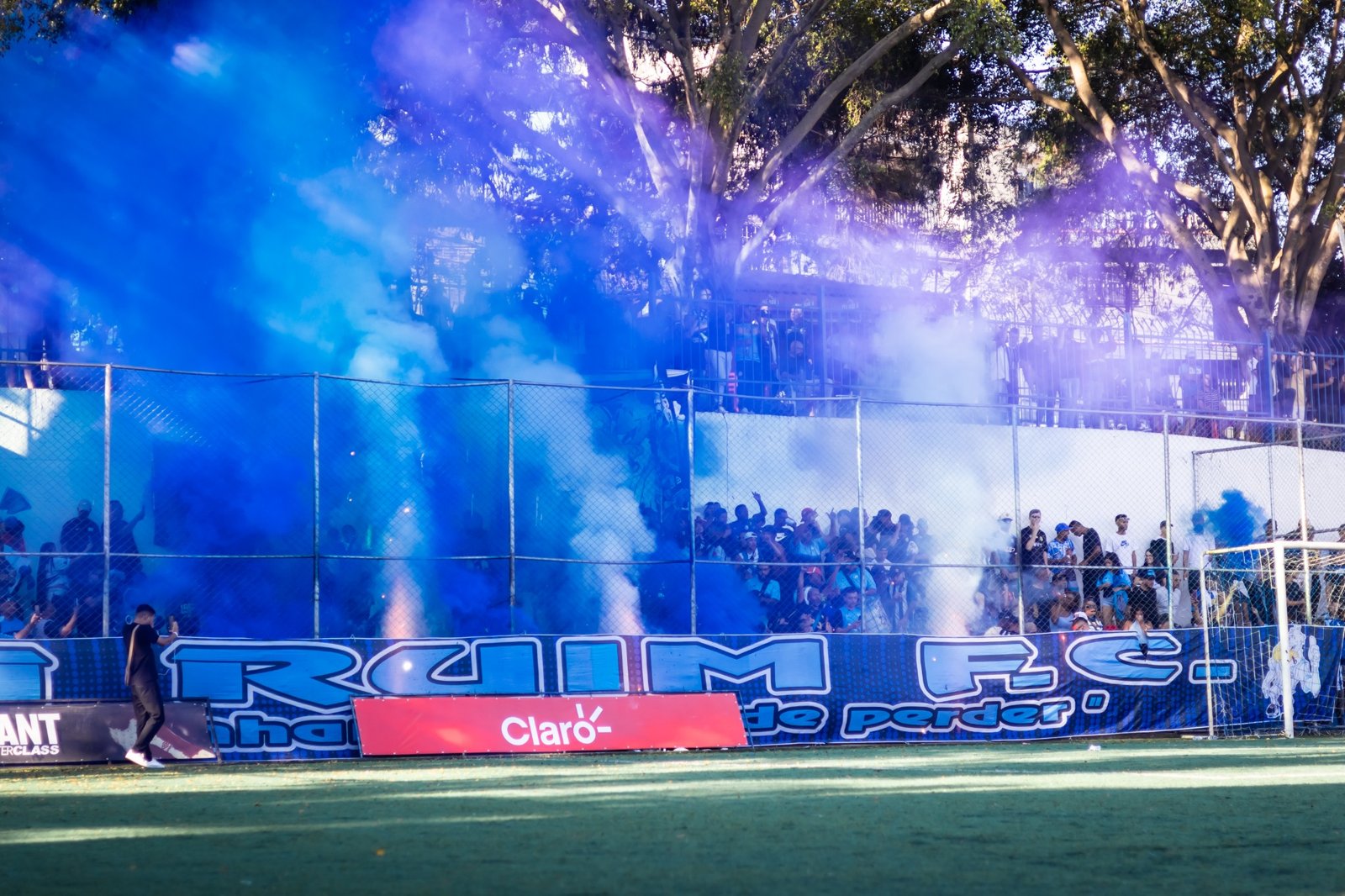 Torcida com fumaça azul diante das marcas no campo